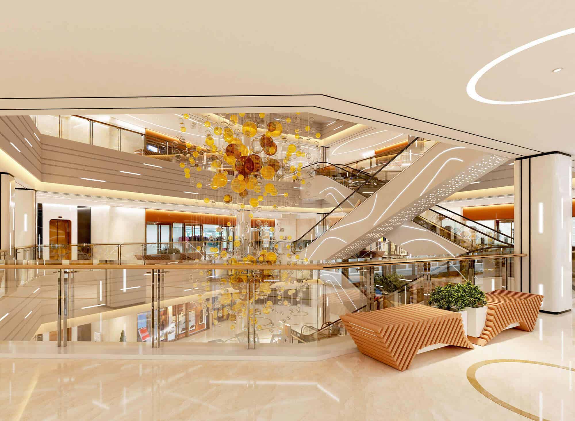 A-multi-level-shopping-center-features-a-prominent-chandelier-hanging-in-the-center,-adorned-with-yellow-and-brown-glass-bulbs-on-transparent-string.