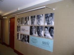 square posters on wall with individuals on each one
