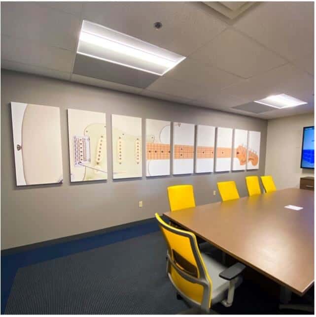a nine piece mural of a cream colored guitar in a meeting room