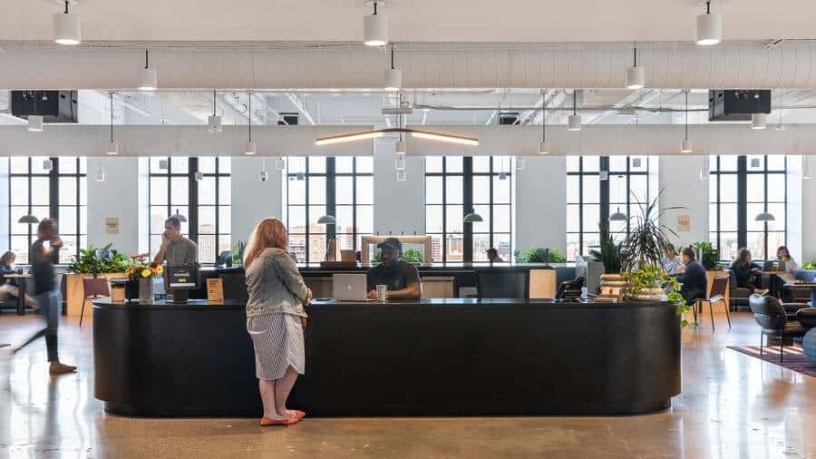 An industrial office with brown floors and a black receptionist desk